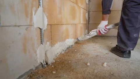 A worker sprays putty on a wall. The process of applying plaster to walls i.. Foto stock