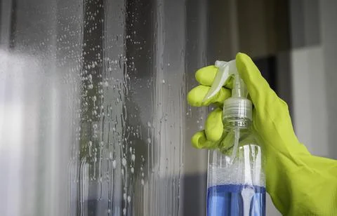 A worker sprays window cleaner. close up. Photos
