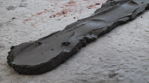 Worker spreading mortar on concrete floor with trowel Stock Footage 314234766