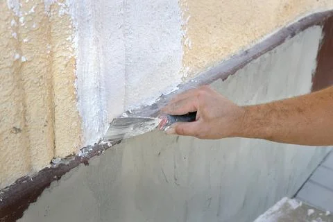 Worker spreading plaster to damaged wall Photos