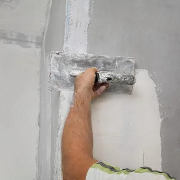 Worker spreading plaster to wall Stock Photos