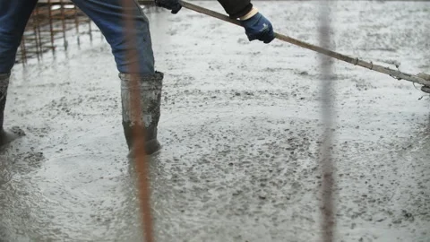 Worker Spreading Wet Concrete at Construction Site Stock Footage 297498254