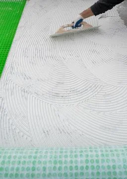Worker Spreading White Tile Adhesive With Notched Trowel Stock Photos