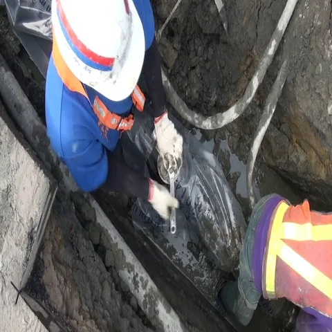 A worker is squeezing a new underground water pipe with a wrench. Stock Footage 69423267