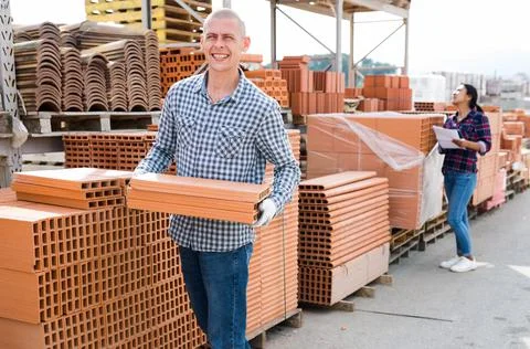 Worker stacking bricks in warehouse of materials 写真素材