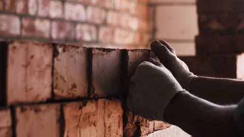 Worker stacking red bricks at construction site Stock Footage 254512057