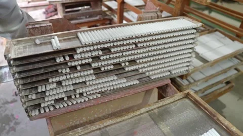 Worker stacking wooden frames filled with drying white chalk sticks in a Stock Footage 342898039