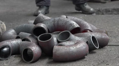 A worker stacks red-hot metal pipes with long tongs. Stock Footage 176849651