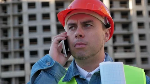 Worker staff in protective helmet using smartphone at construction site Stock Footage 139016664