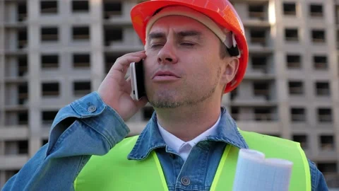 Worker staff in protective helmet using smartphone at construction site Stock Footage 139654431
