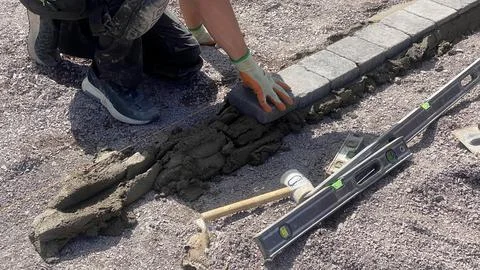 Worker standing on border line, precision placement for garden edging and tur Stock Photos