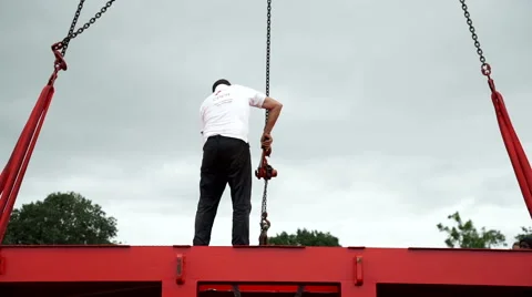 A worker standing on a metal structure suspended by crane. Stock Footage 67427761