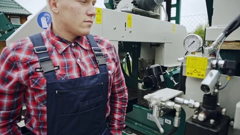 The worker standing near the machine Stock Footage 82789359