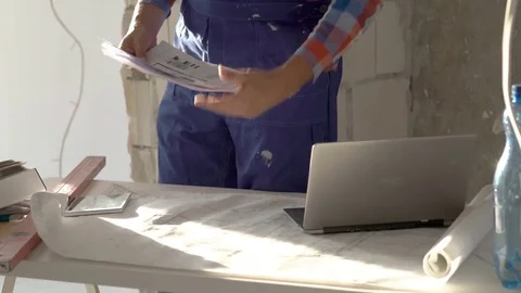 Worker standing in a raw state flate and working on the project, steadycam shot Stock Footage 76493383