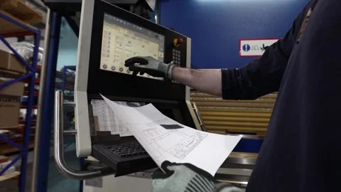 Worker stands at CNC data terminal entering fabrication parameters Stock Footage 306954215