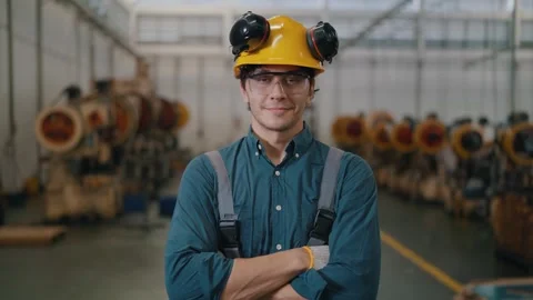 Worker stands confidently in factory setting 库存影片 338066131