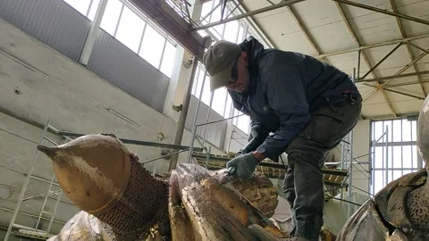 A worker stands on a sculpture and processes a monument to Alexander Nevsky Stock Footage 157781725