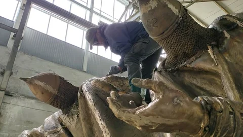 A worker stands on a sculpture and processes a monument to Alexander Nevsky Stock Footage 157783170