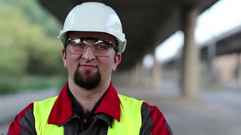 Worker stands under overpass and looks at camera Stock Footage 83185304