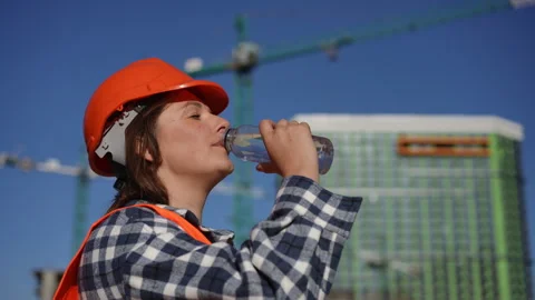 Worker Staying Hydrated Under a Bright, Clear Blue Sky Above Them Stock Footage 311859521