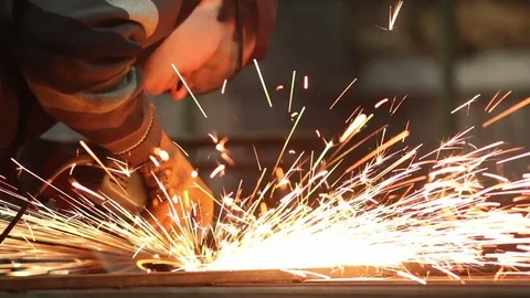 Worker in steel factory using circular blade on a piece of metal Stock Footage 72070775