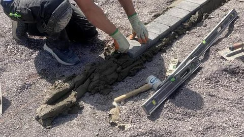 Worker step and alignment on border, outdoor renovation process detail shot. Stock Photos