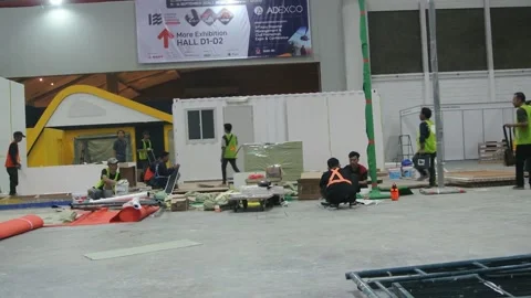  the worker is still working as a booth contractor at mining expo exhibition Stock Footage 290880391