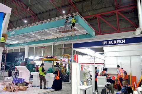 The worker is still working as a booth contractor at mining expo exhibition Foto stock