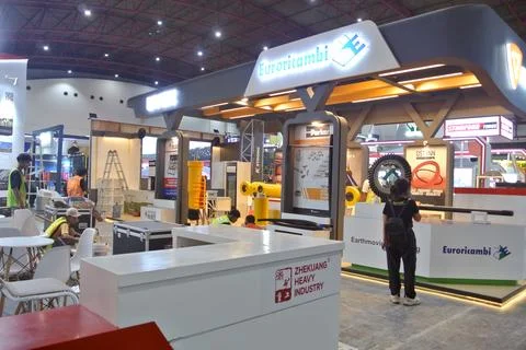 The worker is still working as a booth contractor at mining expo exhibition Stock Photos