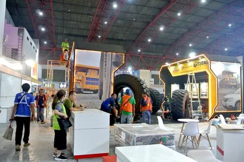 The worker is still working as a booth contractor at mining expo exhibition Stock Photos
