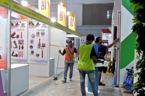 The worker is still working as a booth contractor at mining expo exhibition Stock Photos