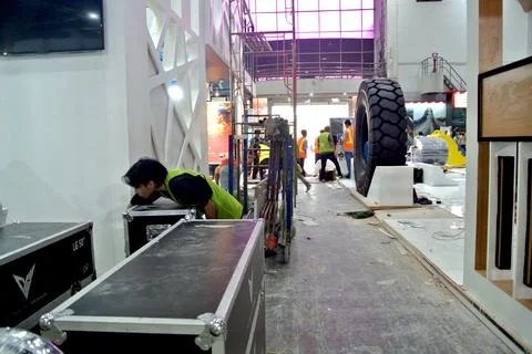 The worker is still working as a booth contractor at mining expo exhibition Stock Photos