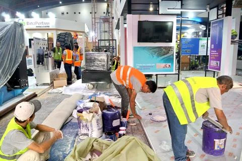 The worker is still working as a booth contractor at mining expo exhibition Photos