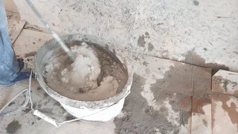 The worker stirs the tile glue with a large mixer. Stock Footage 124227534