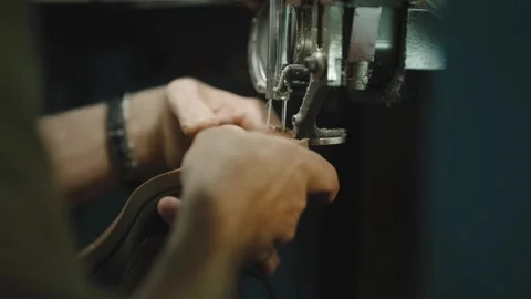 Worker stitching leather shoe welt on industrial sewing machine Stock Footage 333014921