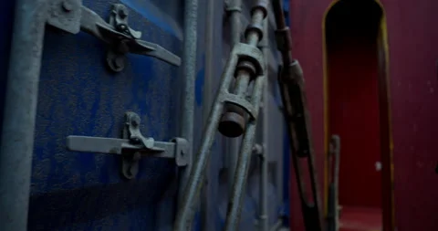 Worker struggles with metal lever unlocking container door Stock Footage 320773713