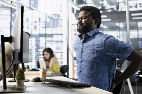 Worker suffering backache from incorrect posture, working with machine learning Stock-Fotos