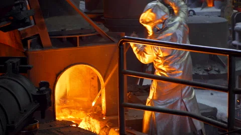 Worker in suit beating iron cast in a furnace - Industry metalurgy Stock Footage 249621003