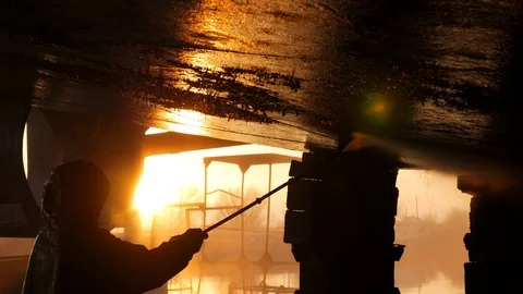 The worker at sunset washes the barge with a stream of water Video stock 87506948
