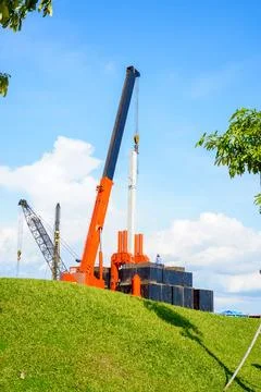 A worker supervises a crane in operation lifting heavy goods Photos