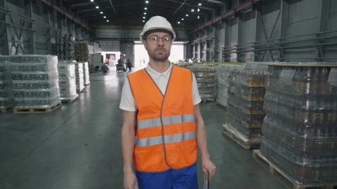 Worker supervising the goods stored inside of the production factory warehouse. Stock Footage 243516069
