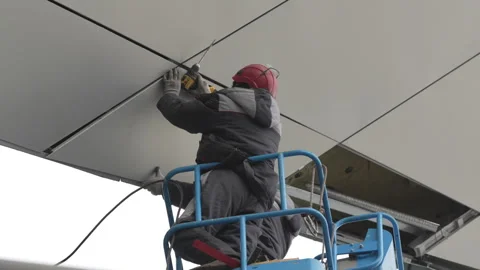 Worker in suspended basket installs cladding tile on facade Video stock 316092013