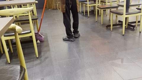 Worker Sweeping Floor with Pink Broom in Restaurant Indoor Stock Footage 328906795
