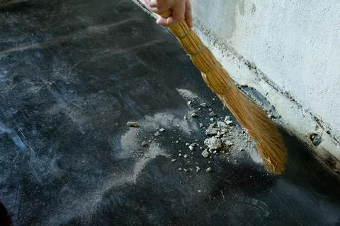 Worker sweeps construction debris with a broom. 스톡 사진