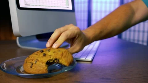Worker Takes a Break with Cookies at the Computer 動画素材 285787662