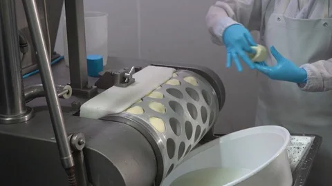 A worker takes cheese out of machine in the process of making cheese in facto Stock Footage 129928098