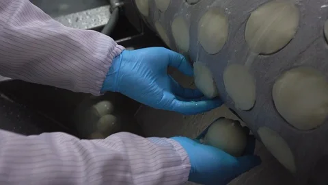 A worker takes cheeses out of machine Stock Footage 129928146