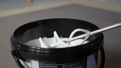 Worker takes out a construction mixer. white paint in a black bucket  Stock Footage 157428393