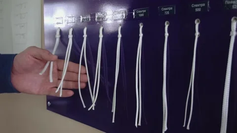 Worker takes parachute laces samples on display in workshop Stock Footage 236907831
