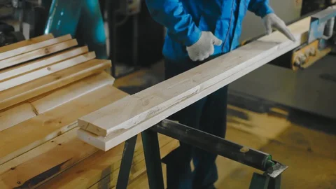 Worker takes planks from woodworking machine Stock Footage 129236905